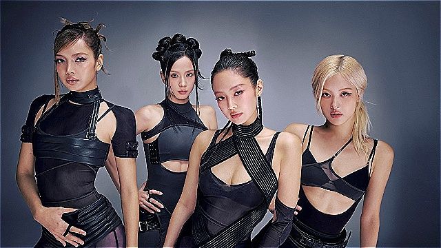 The four members of BLACKPINK posing in black outfits against a gray backdrop